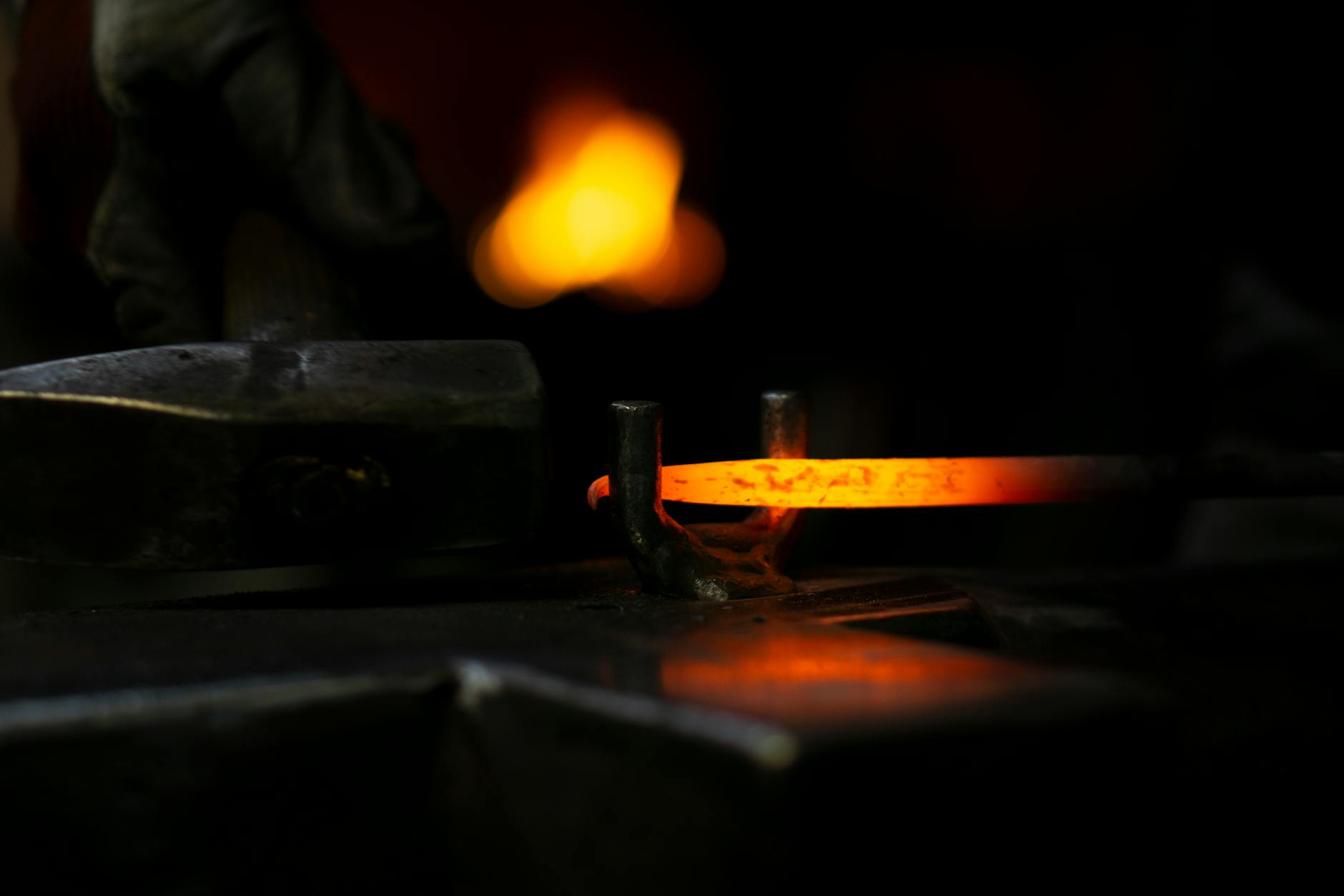 Intense close-up of a blacksmith hammering hot metal, showcasing traditional metalwork skills.